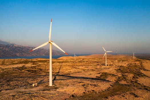 PAG ISLAND, CROATIA - JULY 14 2024: Wind turbines placed on Pag Island for alternative energy production. Modern technology to transform wind into sustainable source of power in Croatia