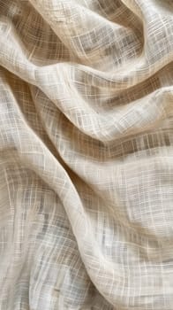 Close-up of a beige fabric with a subtle grid texture, draped in elegant, flowing waves that suggest softness and high quality