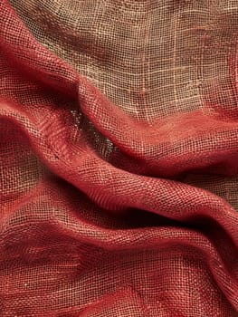 Close-up view of a red burlap fabric with a distinctive weave pattern, evoking a rustic and textured feel suitable for backgrounds or design elements