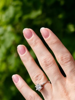 Japanese hygienic manicure on the female hand of the bride with a wedding ring. Clean and safe manicure. Beautiful fingers and nails without gel polish. Vertical