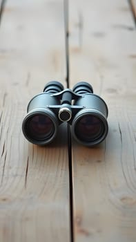 A vintage pair of binoculars rests on a wooden table, ready for outdoor adventures. Perfect for birdwatching, hiking, or enjoying nature, this classic tool invites exploration.