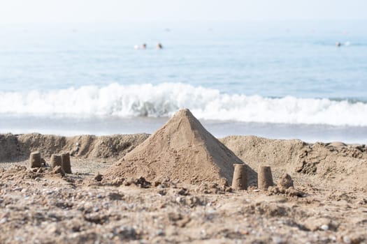 Sand pyramid on the beach with the sea in the background, summer vacation in a tropical country