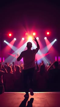 A performer captivates the audience at a concert, surrounded by colorful lights and cheering fans. The atmosphere is electric as everyone dances and enjoys the music.