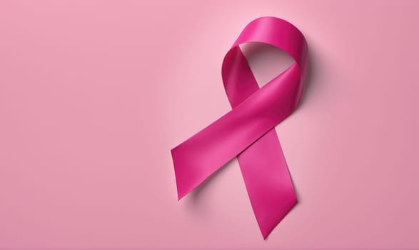 A pink ribbon is tied in a bow shape against a solid pink backdrop.