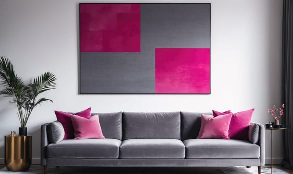 A gray couch with three pink throw pillows is positioned in front of a large framed painting on a white wall. The painting features geometric shapes of grey and pink