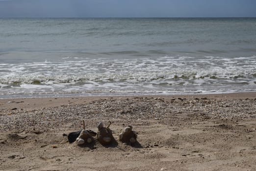 Sand castle with shells built on summer tropical beach. Close up of spade and shells on a beach.