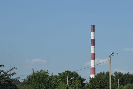 tower of industrial factory. Chimney smokestack emission. Refinery plant with pipes. Plant with smoke frow pipe and environmental pollution. Ecology concept and poor environment.