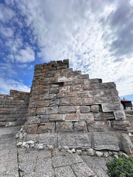 a adobe and stone wall with picturesque house. High quality photo