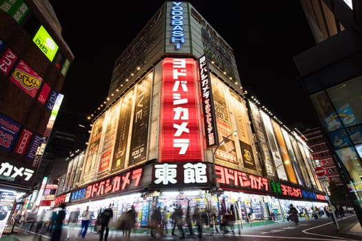 TOKYO, JAPAN - MAY 18 2019: Neon signs illuminate Tokyo’s busy Shinjuku neighborhood at night around Yodobashi camera store