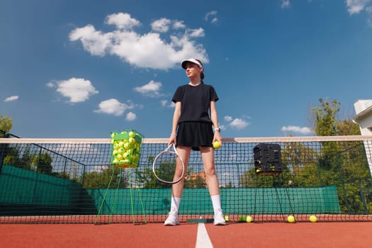 girl tennis player standing on tennis court holding racket and ball against net background preparing for tennis match
