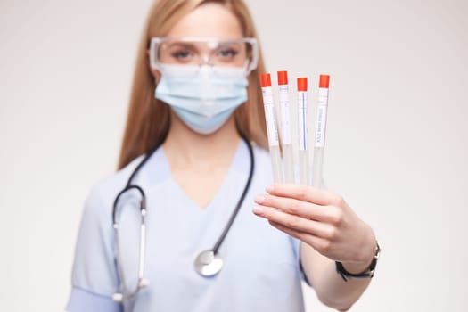 Doctor holding sterile swab stick close up on white background, analysis of medical test results, face mask for safety in clinic, medical tests