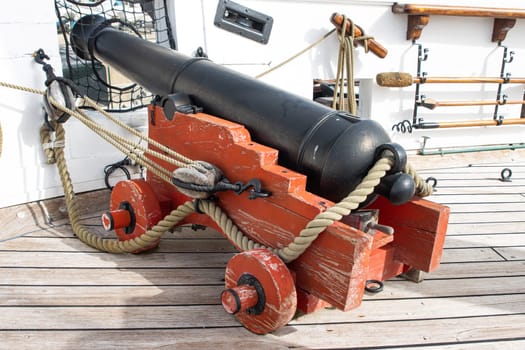 Historirical old metal cannon on battle sailing vessel - stand on deck