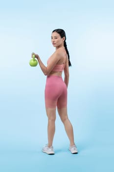 Vigorous energetic woman doing kettlebell weight lifting exercise on isolated background. Young athletic asian woman strength and endurance training session as body workout routine.