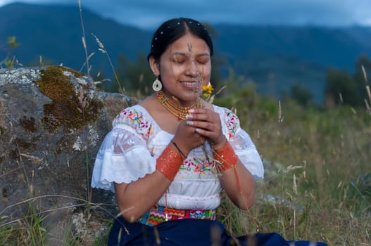 young and beautiful indian girl with her eyes closed in traditional dress feeling the inner peace and relaxation that comes from the nature of latin america. Hispanic Heritage Month. High quality photo