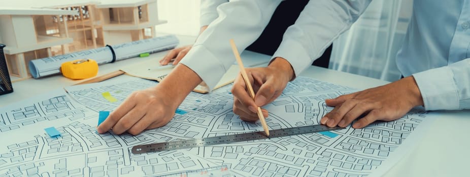 Worker, architect and engineer work on real estate construction project oratory planning with cartography and cadastral map of urban town area to guide to construction developer business plan of city