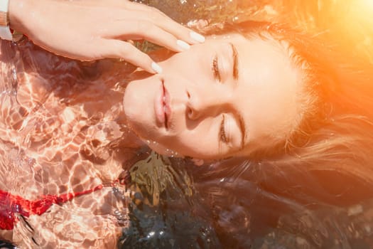 Side view a Young beautiful sensual woman in a mint long dress posing on a volcanic rock high above the sea during sunset. Girl on the nature on overcast sky background. Fashion photo