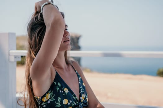 Happy woman portrait in cafe. Boho chic fashion style. Outdoor photo of young happy woman with long hair, sunny weather outdoors sitting in modern cafe