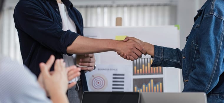 happy professional businessmen shaking hands after a successful financial deal at a meeting..