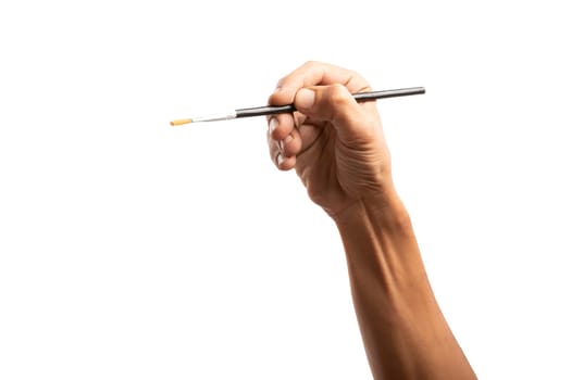 Black male hand holding a paint brush