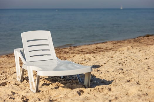 white plastic lounger on the background of the sea