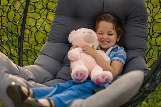 girl playing with her teddy bear being in nature