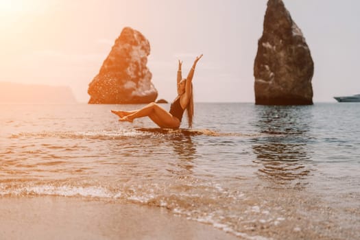 Woman travel sea. Young Happy woman in a long red dress posing on a beach near the sea on background of volcanic rocks, like in Iceland, sharing travel adventure journey