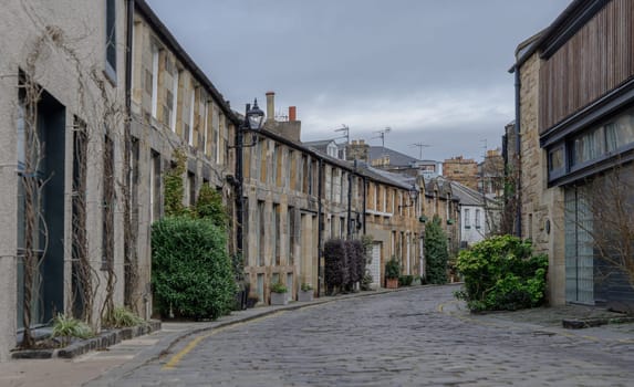 Edinburgh, Scotland - Jan 16, 2024 - Perspective view of Circus Lane is a picturesque cobbled street in Stockbridge of Edinburgh, This residential street with pretty flower-covered terraced mews houses. Copy space, Selective focus.