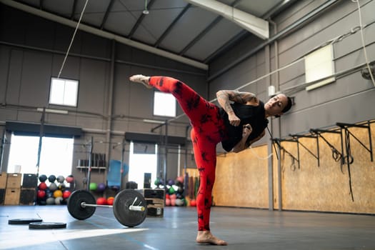 Sportive strong woman throwing a kick in the air in the gym