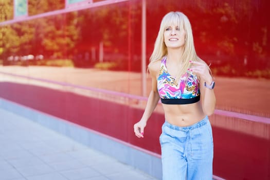 Professional blonde beauty caucasian young female dancer performing happily in the street