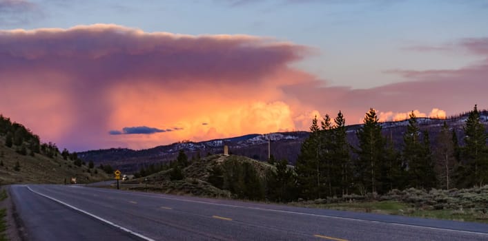 A beautiful red sunset over the mountains overgrown with coniferous forest. USA