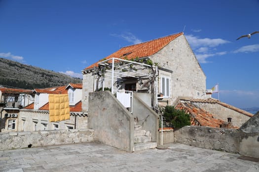 Dubrovnik, Croatia, old town, tiled roof of a house ancient stone building with a triangular facade top view travel places, windows blue sky landscape architecture April 22, 2023. High quality photo
