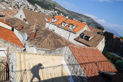 Dubrovnik, Croatia, old town tiled roof of a house ancient stone building with a triangular facade top view travel places, windows blue sky landscape architecture April 22, 2023. High quality photo