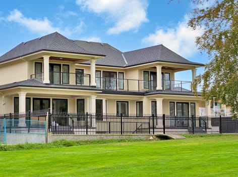 A perfect neighbourhood. New luxury residential house on blue cloudy sky background.