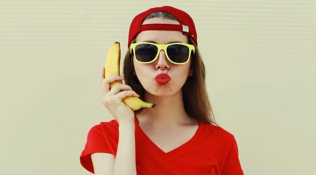 Portrait of funny woman calling on a banana phone on a white background