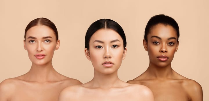 Portrait Of Three Sensual Diverse Girls Wrapped In Bath Towels Standing Posing In Studio Over Gray Background. Beauty Spa Concept.