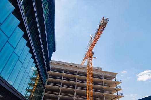 modern construction of glass buildings, concept of modern construction technologies. crane on construction site