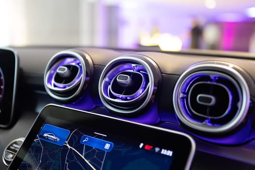 Close-up of a luxury car's interior dashboard, showcasing advanced technology and design with stylish air vents.