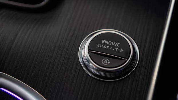 Pressing Stand By Power Button To Turn On and Off the Electric Car Close-Up. Push start stop button of ev car. Finger press the button to start the car engine. Concept of transportation and technology