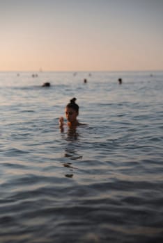 A beautifully tranquil scene of an individual swimming gracefully at sunset, surrounded by calm ocean waters