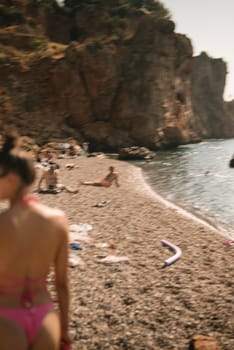 A beautiful and serene beach scene where numerous sunbathers are joyfully enjoying a warm summer day by the water