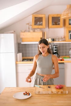 A joyful woman enthusiastically prepares a healthy and delicious snack in her stylish, modern kitchen venue