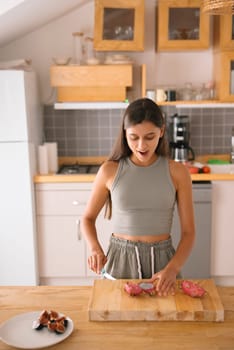 A woman skillfully and expertly slices a variety of colorful ingredients in her stylish and modern kitchen