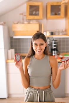 A joyful woman proudly showcases a variety of healthy snacks in a beautifully designed contemporary kitchen environment