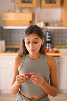 In a contemporary and stylish kitchen setting, a woman looks genuinely surprised as she examines a package carefully