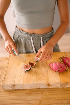 A vibrant scene of a person slicing open dragon fruit, showcasing freshness and culinary creativity.