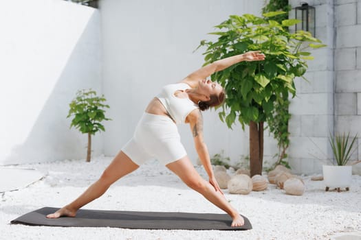yoga stretching outdoors. side view of overweight woman practicing yoga on white background, body care concept, outdoor workout