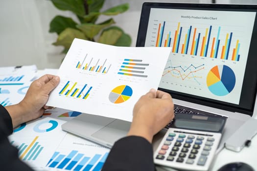 Asian accountant working and analyzing financial reports project accounting with chart graph in modern office, finance and business concept.