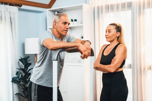 Active senior couple running on tread running machine at home together as fitness healthy lifestyle and body care after retirement for pensioner. Clout