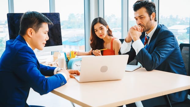 Smart businessman and businesswoman talking discussion in group meeting at office table in a modern office interior. Business collaboration strategic planning and brainstorming of coworkers. Jivy