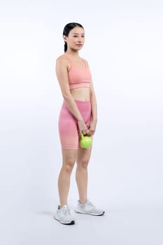 Vigorous energetic woman doing kettlebell weight lifting exercise on isolated background. Young athletic asian woman strength and endurance training session as body workout routine.